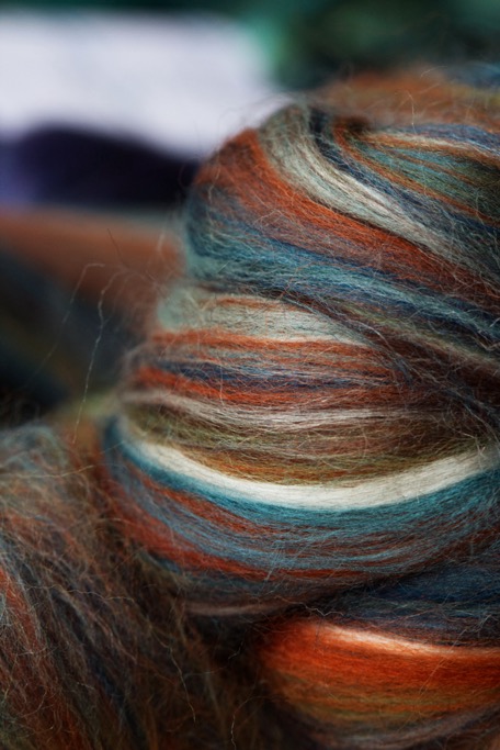 Fiber top in shades of brown, turquoise, cream and orange, ready to be spun