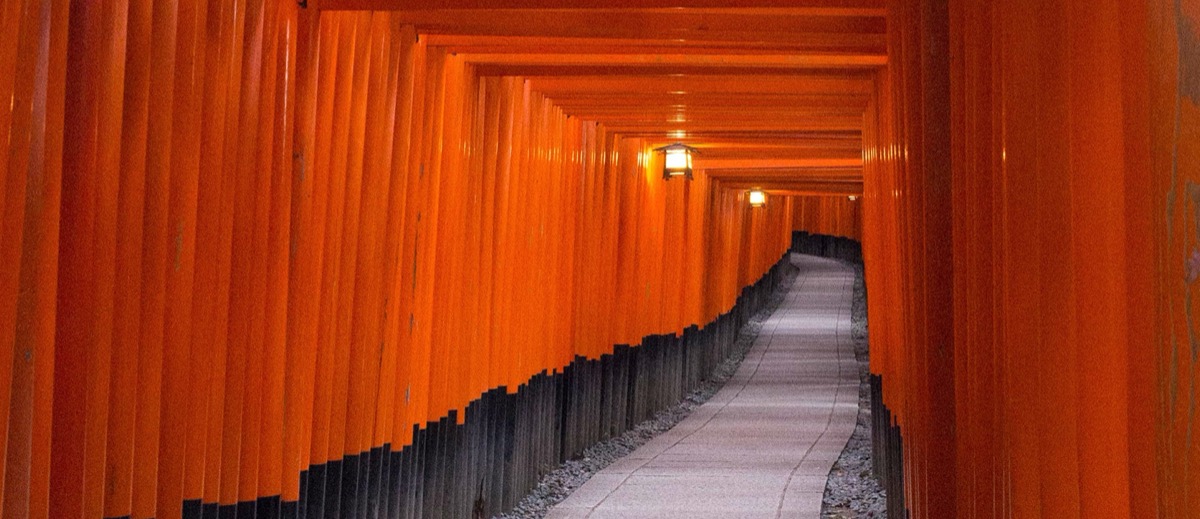The red and black torii gates over stairs leading upwards in the Fushimi Inari Taisha shrine in Kyoto, Japan