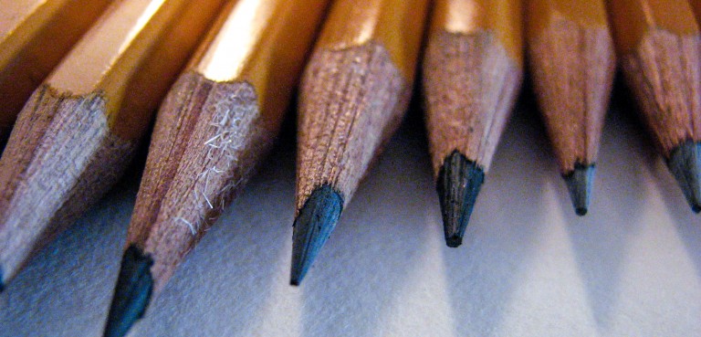 A handful of lead pencils lined up diagonally with sharp points, ready to be used