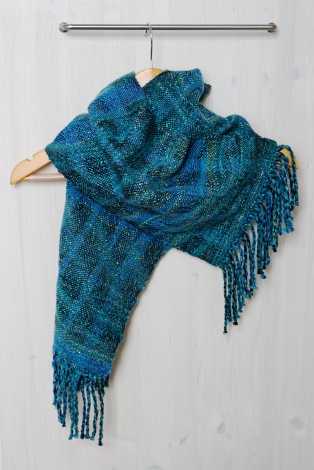 A blue scarf woven in wavy lines hangs from a handle in a kitchen