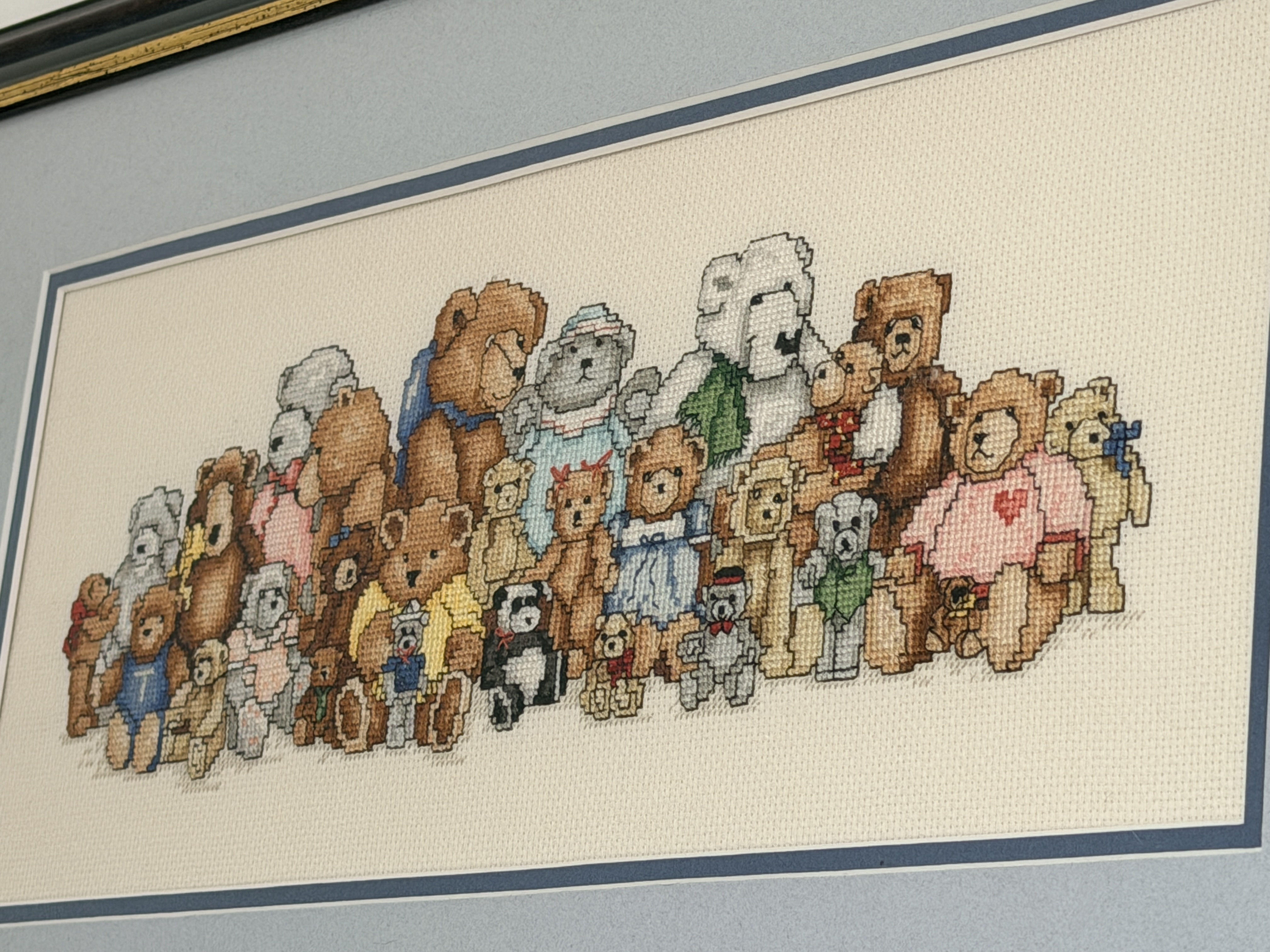 A teddy bear cross stitch in a frame