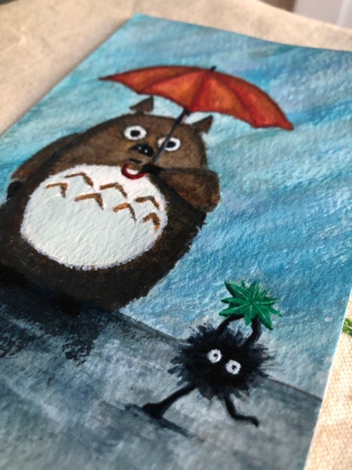 A watercolour card of Totoro under his umbrella and a soot sprite carrying a star